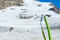 Ice axe positioned in snow with mountaineers walking in the background. Royalty Free Stock Photo