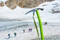 Ice axe positioned in snow with mountaineers walking in the background. Royalty Free Stock Photo