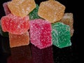 Cubes of jelly on a black reflective background