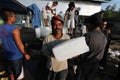 Ice block worker moving ice from truck to fishing boat