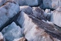 Ice blocks covered with black sand. Broken ice floes during ice drift on the river.