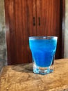 Ice blue Hawaii soda drink in shot Glass on the cement floor Royalty Free Stock Photo