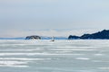 Ice boat rides on the ice of Lake Baikal in the background Olkhon in the winter foggy morning away Royalty Free Stock Photo