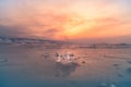 Ice breaking over frozen water lake with sunset sky background, Baikal Russia Royalty Free Stock Photo