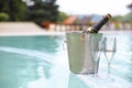 Ice bucket champagne bottle and two glasses near pool Royalty Free Stock Photo