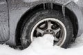 Ice buildup and icicles on a car and close-up of a frozen wheel