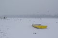 Ice capured yellow boat and people feeding birds on frozen Danube river Royalty Free Stock Photo