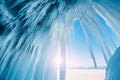 Ice cave with icicles in Baikal lake at sunset.