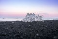 Ice chunk washed up on a black beach with lava sand during sunset hours Royalty Free Stock Photo