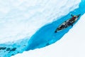 Ice climber canoeing in narrow ice canyon from above