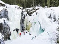 Ice climbers mountaineers climb up frozen waterfall Rjukandefossen, Hemsedal, Norway