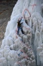 Ice climbing competition. Climbers climb an ice cliff Royalty Free Stock Photo