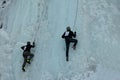 Ice climbing competition. Climbers climb an ice cliff Royalty Free Stock Photo