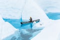 Ice climbing guide on the Matanuska Glacier paddling a canoe through narrow flooded canyons of a glacier lake