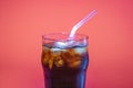 Ice coffee in a glass glass with tube on a dark pink background, a copy of the space Royalty Free Stock Photo