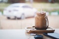 Ice coffee Key and smart phone in cafe with car parked in background Royalty Free Stock Photo