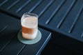 Ice coffee latte macchiato on a wood table with cream being poured into it showing the texture and refreshing look of the drink,Fr Royalty Free Stock Photo