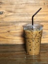 Ice coffee in plastic cup and brown tube on the wooden table, Royalty Free Stock Photo