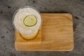 A plastic glass of ice honey lemon with sparking water is on a saucer wood, top view