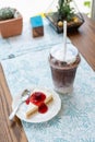 Ice coffee take away and cake on wooden background Royalty Free Stock Photo