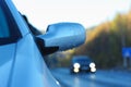 Ice-covered car rear view mirror against road Royalty Free Stock Photo