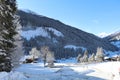 an ice covered rural road and some farm houses in a mountain valley on a beautiful cold winter morning with fresh snow Royalty Free Stock Photo