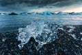 Ice cracked on black beach and iceberg floating in Jokulsarlon glacier lagoon Royalty Free Stock Photo