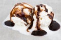 Ice cream balls with chocolate sauce on gray background, top vie