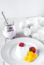 Ice cream with berries in white plate, yogurt and egg