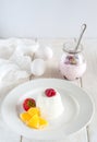 Ice cream with berries in white plate, yogurt and egg