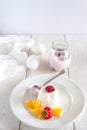 Ice cream with berries in white plate, yogurt and egg