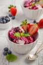 Ice cream with blueberries and strawberries in white bowl on white wooden background Royalty Free Stock Photo