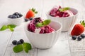 Ice cream with blueberries and strawberries in white bowl on white wooden background Royalty Free Stock Photo