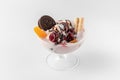 Ice cream bowl with fresh frozen yogurt, fruits, cookies and cherries isolated on a white and gray background with natural shadows Royalty Free Stock Photo