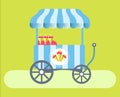 Ice cream cart with striped tent on green medow