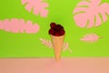 ice cream with cherries in a cone on a pink-green background with jungle leaves pink, creative summer design Royalty Free Stock Photo