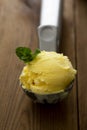 Ice cream closeup scoop, round icecream ball in scoop spoon on rustic wooden background