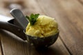 Ice cream closeup scoop, round icecream ball in scoop spoon on rustic wooden background