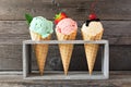 Ice cream cone assortment against a wood background, mint, strawberry and vanilla flavors