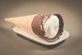 ice cream with cone in chocolate on a white plate/ice cream with cone in chocolate on a white plate on a dark background Royalty Free Stock Photo