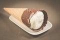 ice cream with cone in chocolate on a white plate/ice cream with cone in chocolate on a white plate, selective focus Royalty Free Stock Photo