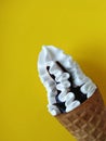 Ice cream cone with chocolate on a yellow background.