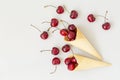 Ice cream cone filled with cherries on a grey light background. Fresh cherry in a waffle cone. Summer concept. Royalty Free Stock Photo