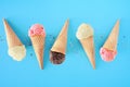 Ice cream cone flat lay over a blue background with vanilla, strawberry and chocolate flavors Royalty Free Stock Photo