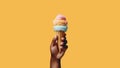 Ice cream cone on hand on yellow background