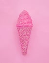 Ice cream cone made from confetti with tasty cream on pink paper background. Trendy minimal pop art style and summer food concept. Royalty Free Stock Photo