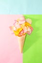 ice cream cone with rose petals on pink-green-blue background, summer design, romantic creative summer design