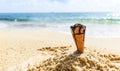 Ice cream cone on sand beach background - Melting ice cream on beach sea in summer hot weather ocean landscape nature outdoor Royalty Free Stock Photo