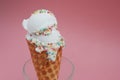 Ice Cream cone with scoop of Vanilla ice cream and Confetti in glass on Pink background. top view. Party, dessert, summer