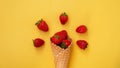 Ice cream cone with strawberries on a yellow background Royalty Free Stock Photo